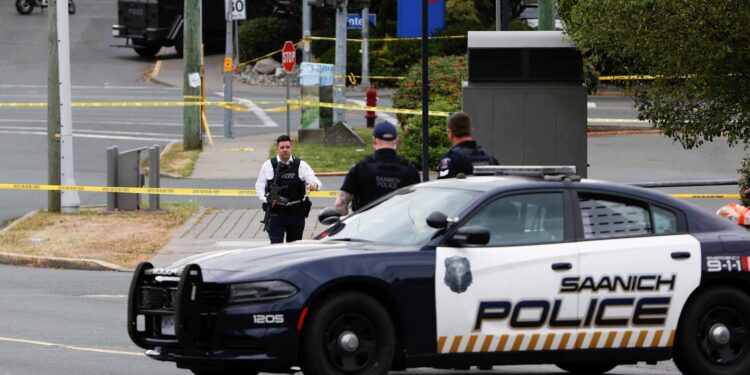 Police officers gather after two armed men entering a bank were killed in a shootout with the police in Saanich, British Columbia, Canada June 28, 2022. REUTERS/Kevin Light مراهقان يتعرضان للطعن خارج مركز تجاري في ميسيساجا