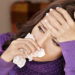Young woman with handkerchief having cold. Isolated. تجنب الاصابة بالانفلونزا بهذه الطريقة